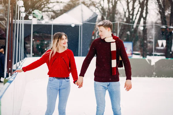 Casal bonito em uma camisola vermelha se divertindo em uma arena de gelo — Fotografia de Stock