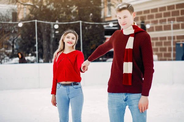 Coppia carina e amorevole in maglioni rossi in una città invernale — Foto Stock