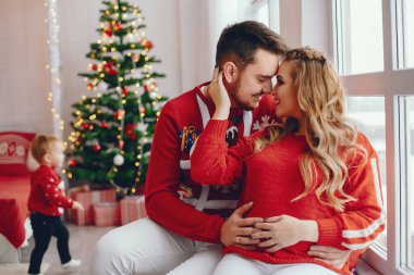 Noel ağacının yanında oturan sevimli bir aile.