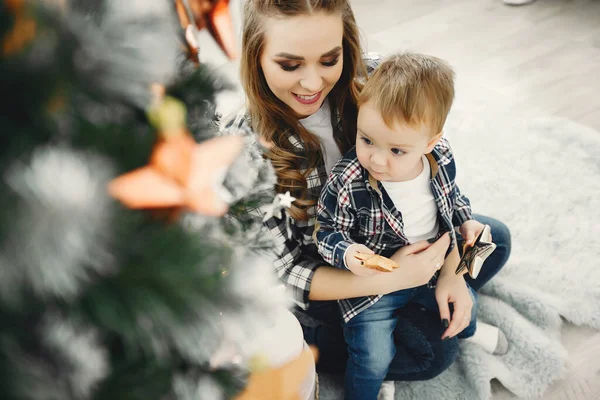 Jolie famille assise près du sapin de Noël — Photo