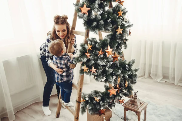 Linda familia sentada cerca del árbol de Navidad — Foto de Stock