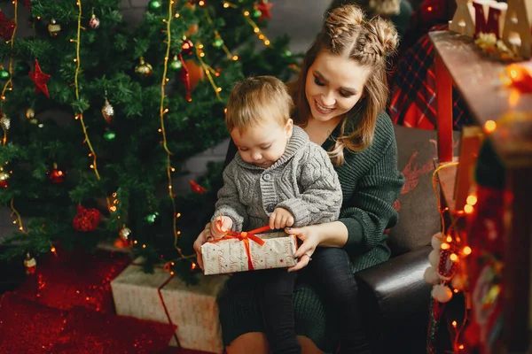 Linda familia sentada cerca del árbol de Navidad — Foto de Stock