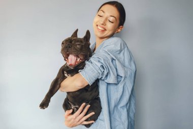 Mavi gömlekli, siyah bulldoglu zarif bir kadın.