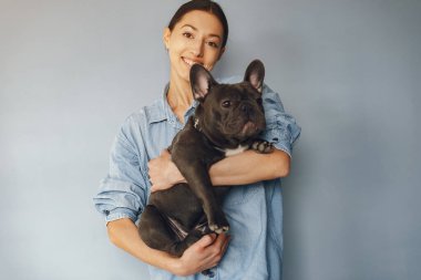 Mavi gömlekli, siyah bulldoglu zarif bir kadın.