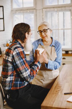Son sınıf çifti mutfakta çayla oturuyor.