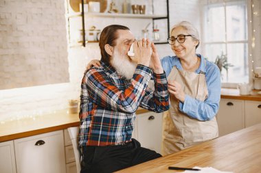 Son sınıf çifti mutfakta çayla oturuyor.