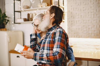 Mutfakta hediyeleri olan yaşlı bir çift.