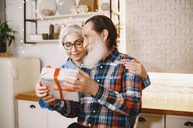 Mutfakta hediyeleri olan yaşlı bir çift.