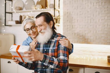 Mutfakta hediyeleri olan yaşlı bir çift.