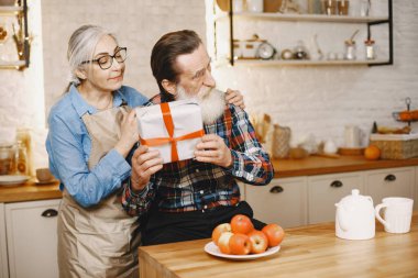Mutfakta hediyeleri olan yaşlı bir çift.