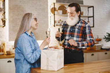 Mutfakta hediyeleri olan yaşlı bir çift.