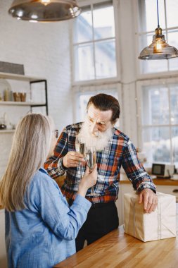 Mutfakta hediyeleri olan yaşlı bir çift.