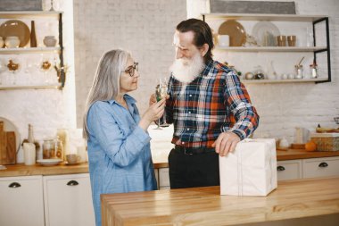 Mutfakta hediyeleri olan yaşlı bir çift.