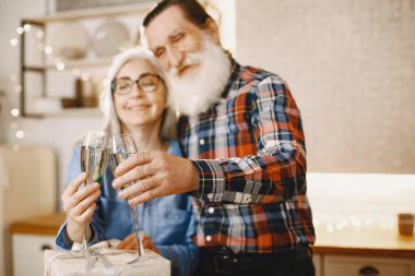 Mutfakta hediyeleri olan yaşlı bir çift.