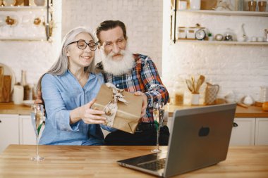 Mutfakta hediyeleri olan yaşlı bir çift.