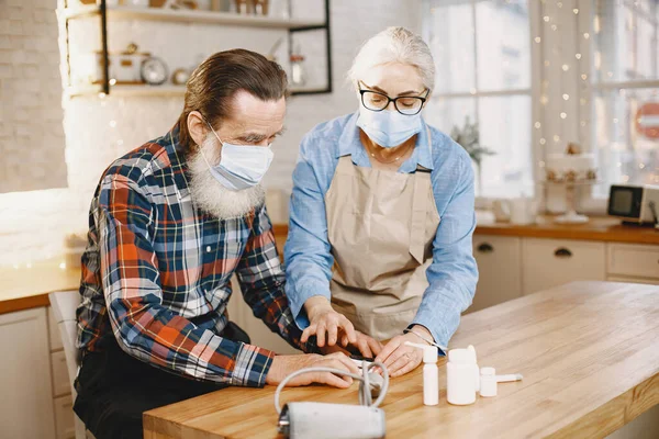 Seniorin und Mann zu Hause messen Blutdruck — Stockfoto