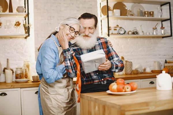 Mutfakta hediyeleri olan yaşlı bir çift.