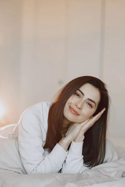 Woman lying on a bed in a bedroom — Stock Photo, Image