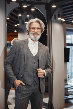 Üst düzey bir adam mağazadan yeni bir takım elbise seçiyor.