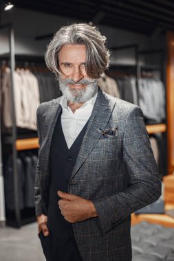 Üst düzey bir adam mağazadan yeni bir takım elbise seçiyor.