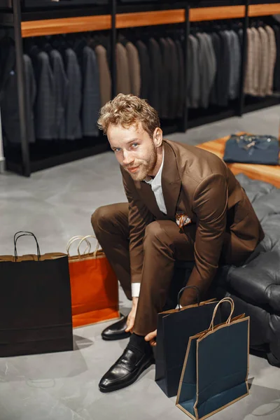 Hombre guapo con barba eligiendo zapatos en una tienda —  Fotos de Stock