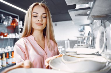 Pembe bluzlu kadın dükkandan yemek alıyor.