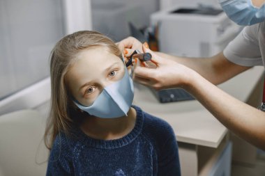 Muayene için doktordaki küçük mutlu kız.