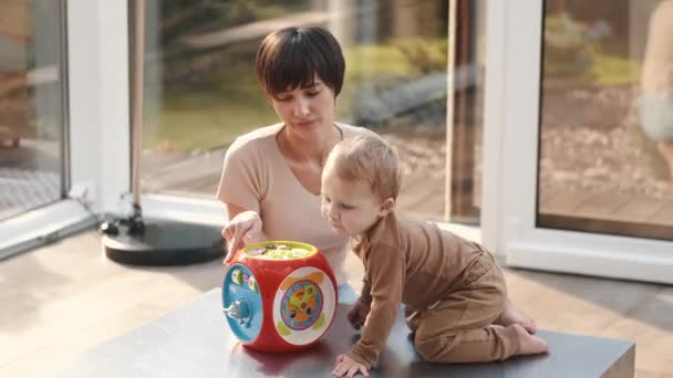Matka a malý syn se smějí a hrají si doma na pedagogické hračky — Stock video