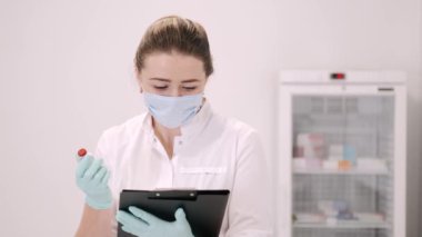 Reçeteli not defteri olan kadın doktor covid-19 aşısı gösteriyor.