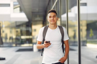 Üniversite kampüsünde telefonlu bir öğrenci.