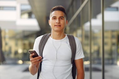 Üniversite kampüsünde telefonlu bir öğrenci.