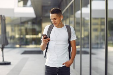 Üniversite kampüsünde telefonlu bir öğrenci.