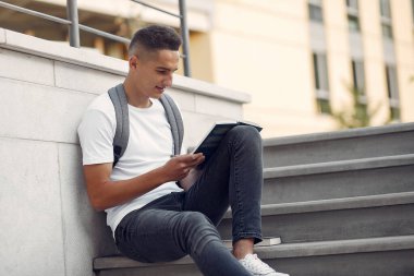 Üniversite kampüsünde elinde kitaplarla bir öğrenci.