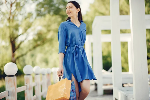 Linda chica con bolsa de compras en un parque —  Fotos de Stock