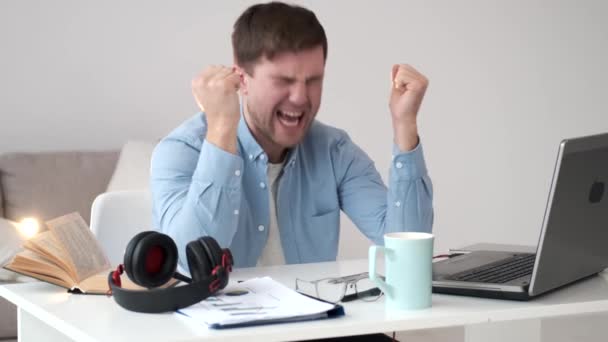Jovem empresário gritando de frustração enquanto trabalhava no laptop em casa — Vídeo de Stock
