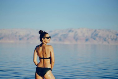 Esmer kız ölü denizde yüzüyor.