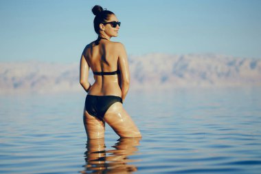 Esmer kız ölü denizde yüzüyor.