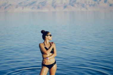 Esmer kız ölü denizde yüzüyor.