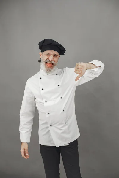 Szef kuchni w białym mundurze na szarym tle — Zdjęcie stockowe