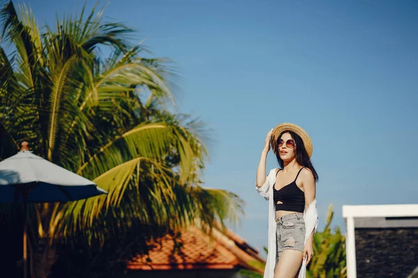 Menina morena relaxante na piscina — Fotografia de Stock