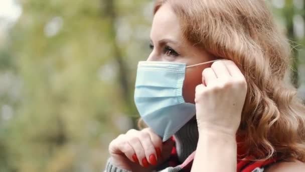 Mujer puesta máscara protectora en un parque — Vídeo de stock