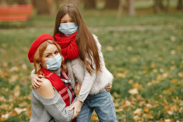 Anne ve kızı maskelerle dışarı çıkıyorlar.