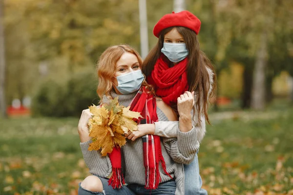 Madre con hija camina afuera con máscaras —  Fotos de Stock
