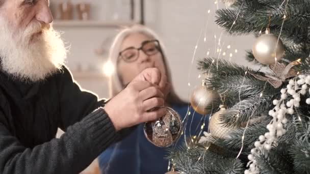 Senioren paar versieren kerstboom samen thuis — Stockvideo
