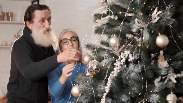 Senioren paar versieren kerstboom samen thuis — Stockvideo