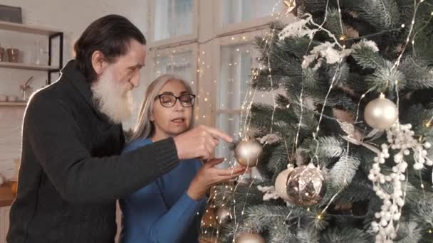 Старшая пара украшает елку вместе дома — стоковое видео