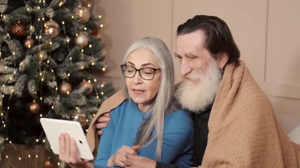 Oudere gepensioneerde paar met digitale tablet hebben video call op Kerstmis — Stockvideo