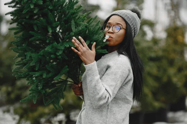 Africká žena vybírá vánoční stromek — Stock fotografie