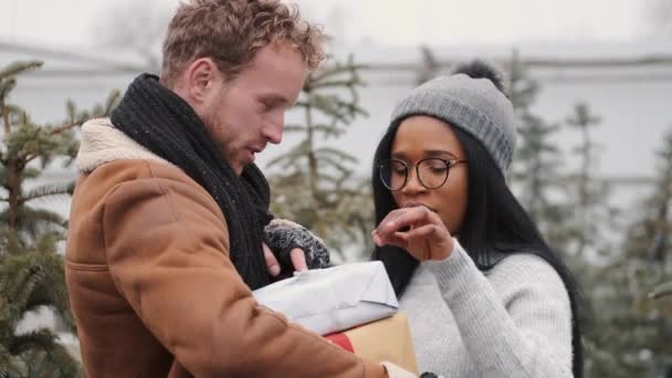 Heureux couple multiracial échangeant des cadeaux au marché de sprue trees — Video