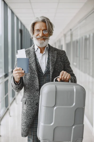 Senior Geschäftsmann mit Reisekoffer im Flughafen — Stockfoto